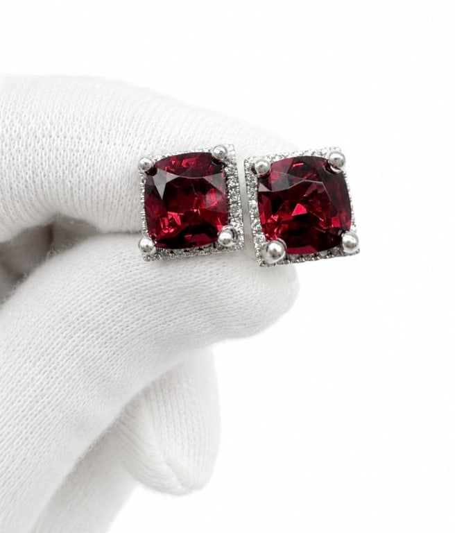 18K WHITE GOLD 3.27CT RHODOLITE GARNET EARRINGS: Pair of 18 karat white gold earrings featuring cushion-cut natural rhodolite garnets with a combined weight of approximately 3.27 carats. The garnets are accented by round brilliant-cut diamonds total