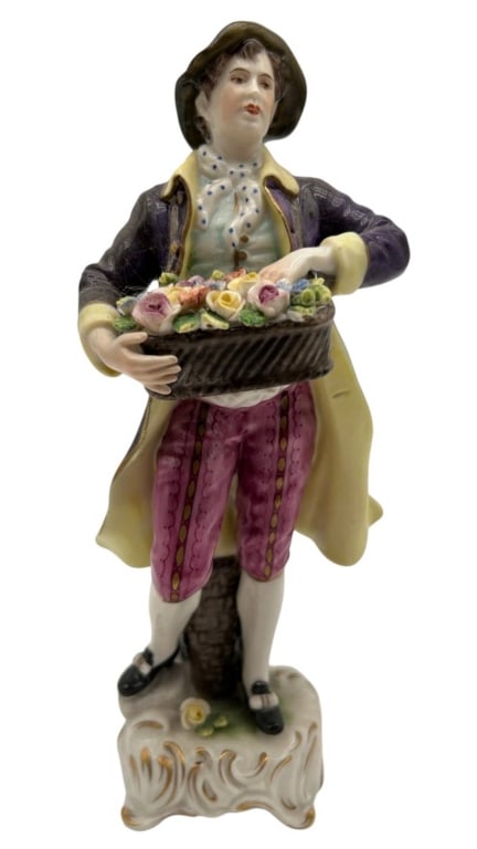 ANTIQUE PORCELAIN FLOWER SELLER FIGURE 8.5": Charming antique Continental porcelain figurine depicting a gentleman flower seller holding a basket overflowing with individually modeled colorful flowers and roses. The figure is finely modeled in p