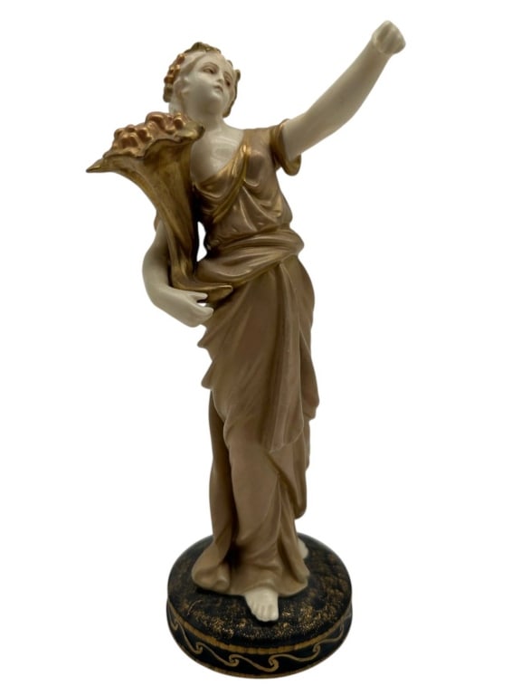 RUDOLSTADT GERMAN PORCELAIN FIGURE 7": Antique German porcelain allegorical female figure by Rudolstadt, modeled as a classically draped woman holding a large cornucopia and raising one arm. Finished in warm ivory and taupe tones with gilt