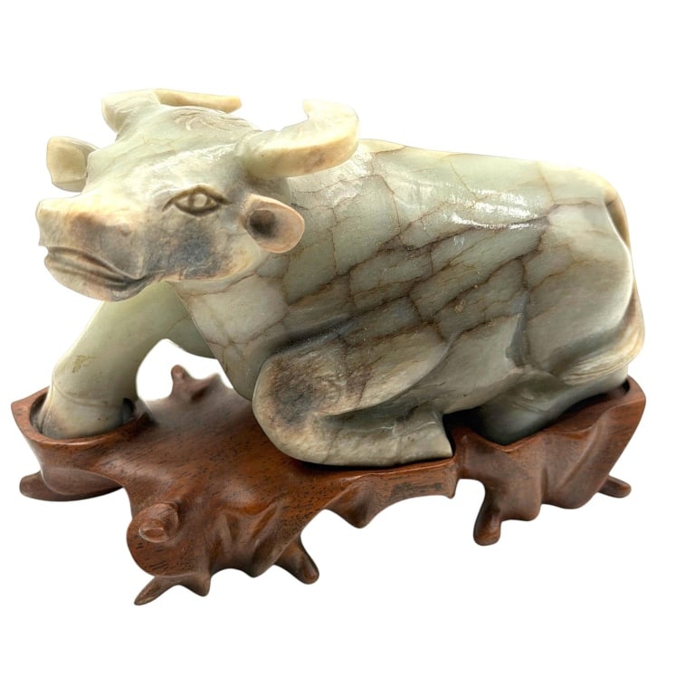 CHINESE CARVED STONE BUFFALO 6": Chinese carved calcite or onyx figure depicting a recumbent water buffalo with one foreleg extended, finely modeled horns, facial features and musculature. The stone displays pale green, cream and
