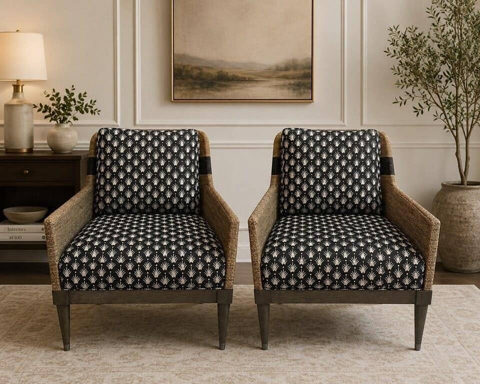 PAIR WOVEN ARMCHAIRS BLACK PALM FABRIC 34": Elegant pair of woven armchairs featuring natural textured sides, dark wood frames, tapered legs, and black upholstered cushions with a white palm motif pattern. The chairs have a refined coastal Palm