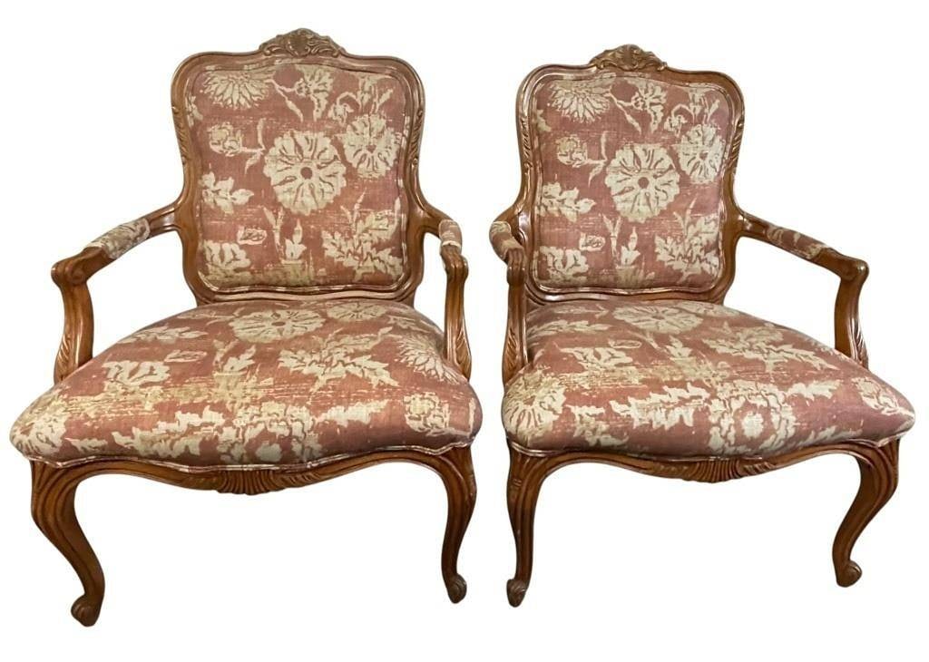 PAIR OF LOUIS XV STYLE UPHOLSTERED ARMCHAIRS 41": Elegant pair of Louis XV-style berg?re armchairs featuring beautifully carved walnut-tone frames with graceful cabriole legs, scrolling arms, and shaped crests. The chairs are upholstered in a sophist