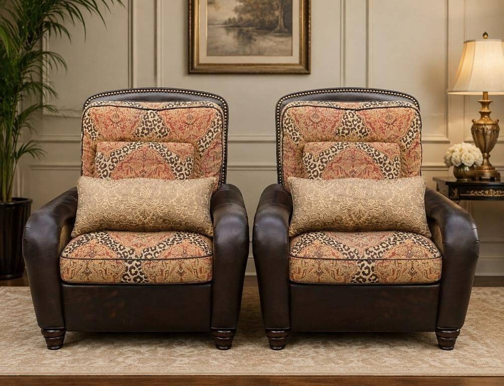 PAIR OF PAISLEY LEATHER RECLINING CLUB CHAIRS 42: Pair of upholstered reclining club chairs featuring dark brown leather-look rolled arms, nailhead trim, turned front feet, and richly patterned paisley and animal-print fabric cushions. Each chair inc