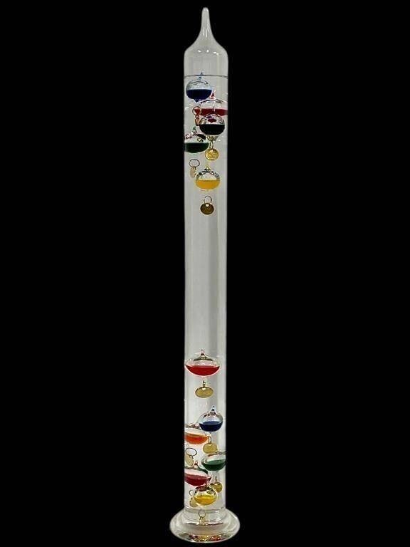 TALL GLASS GALILEO THERMOMETER W COLORS FLOAT 24": This is a classic tall Galileo thermometer featuring a clear glass cylinder filled with floating glass bulbs in vibrant colors including red, blue, yellow, green, and purple. Each bulb is fitted with 