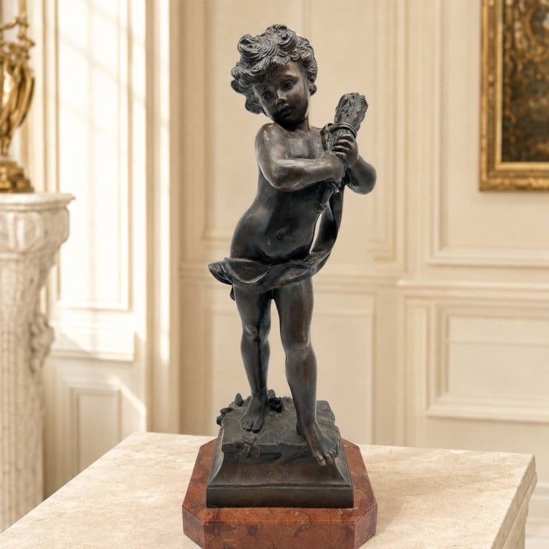 LARGE BRONZE PUTTO WITH WHEAT ON MARBLE 20": Classical bronze sculpture depicting a standing putto holding a bundled sheaf of wheat, traditionally associated with abundance and the harvest season. The finely modeled figure features curled hair, 