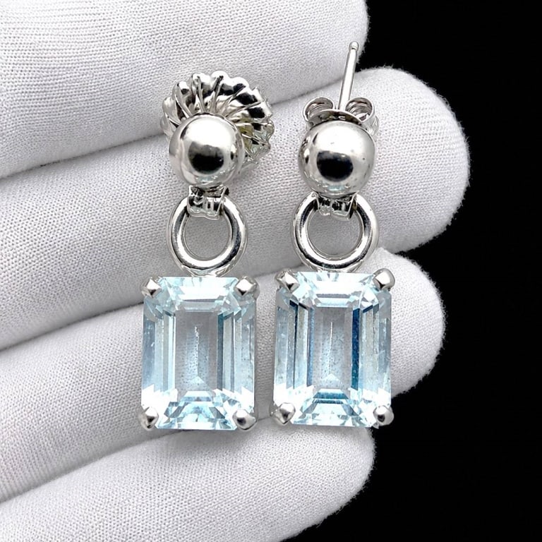 AQUAMARINE & WHITE GOLD EARRINGS: Elegant pair of estate 14K gold drop earrings featuring substantial rectangular emerald-cut natural aquamarines in a pale icy blue hue. Each faceted gemstone is secured in a four-prong setting and sus
