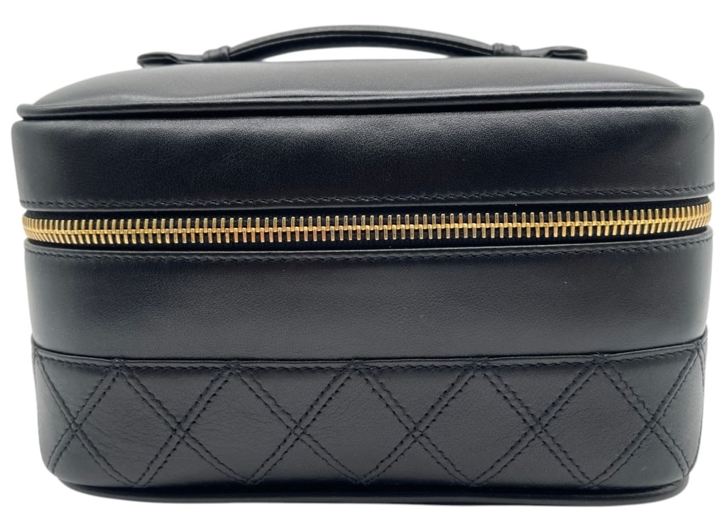 CHANEL QUILTED LEATHER VANITY CASE 7": Chanel vanity case crafted in black leather with quilted detailing along the lower portion and smooth leather panels above. The structured design features a top carry handle, wraparound gold-tone zipp