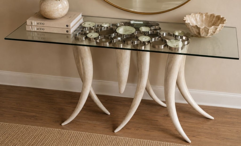 CONTEMPORARY FAUX TUSK GLASS CONSOLE TABLE 60": Contemporary console table featuring a rectangular glass top supported by a sculptural base of faux tusk-form legs with polished metal mounts. The clustered base design creates a striking visual effec