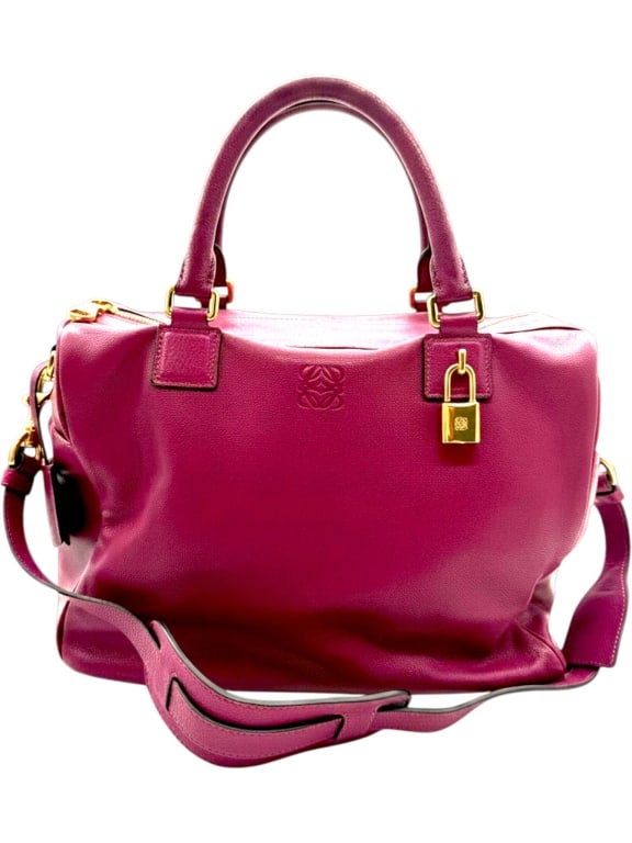 LOEWE AMAZONA MAGENTA LEATHER SATCHEL 12": Crafted in Spain by Loewe, this Amazona satchel is rendered in rich magenta leather with gold-tone hardware and the iconic embossed Loewe Anagram logo centered on the front. The timeless silhouette fe