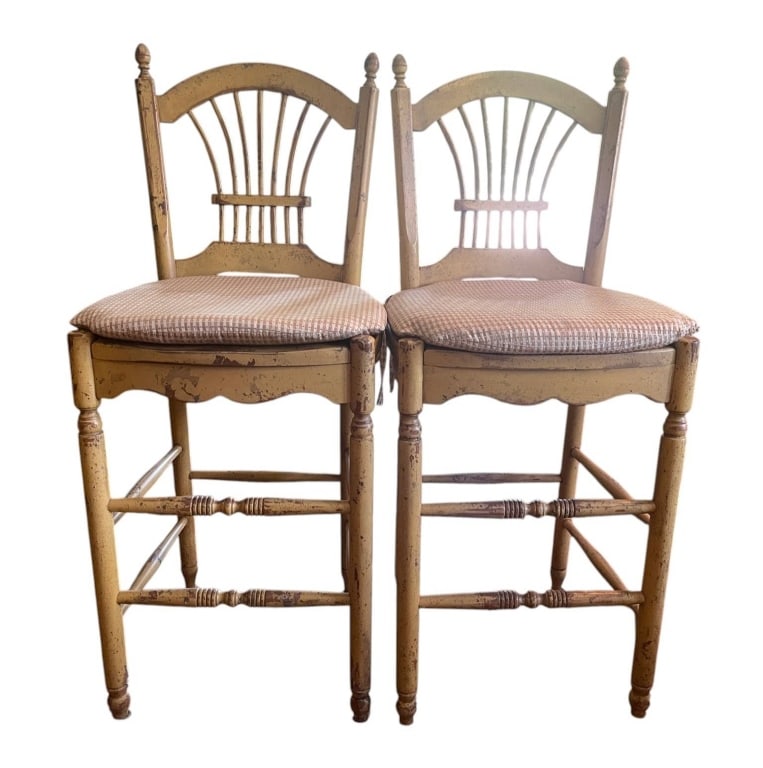 PAIR VINTAGE WOODEN BARSTOOLS 42": Two matching vintage wooden barstools with spindle backs and fabric upholstered seats. The chairs have a distressed yellow finish and classic turned legs. Cushioned seats show moderate wear. | |