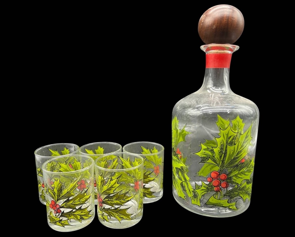 VINTAGE HOLLY BERRY DECANTER & 5 GLASSES 12.5": Charming vintage holiday barware set featuring a clear glass decanter with five matching drinking glasses, each decorated with a bold Christmas holly leaf and red berry motif. The decanter is finished