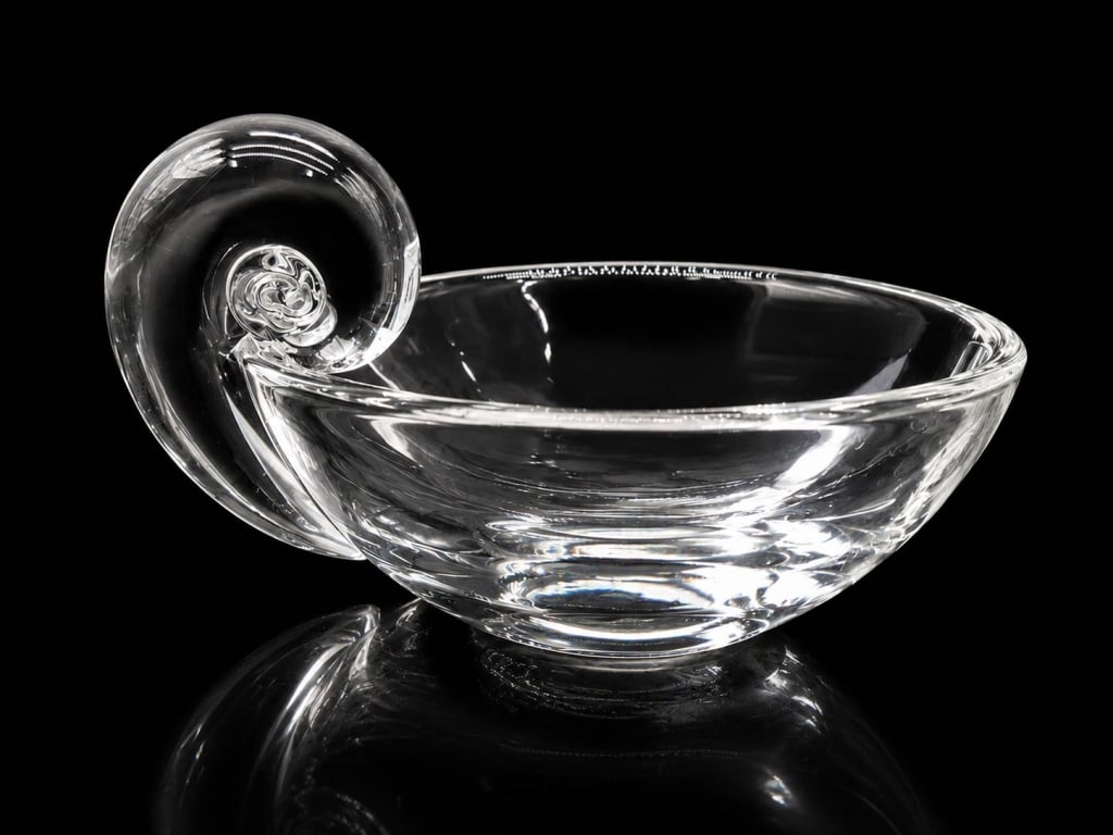 STEUBEN SIGNED CRYSTAL SCROLL BOWL 6": Elegant signed Steuben clear crystal art glass bowl featuring a sculptural curled scroll or ram?s-horn form rising dramatically from one side. Crafted in brilliant, heavy crystal with smooth flowing l