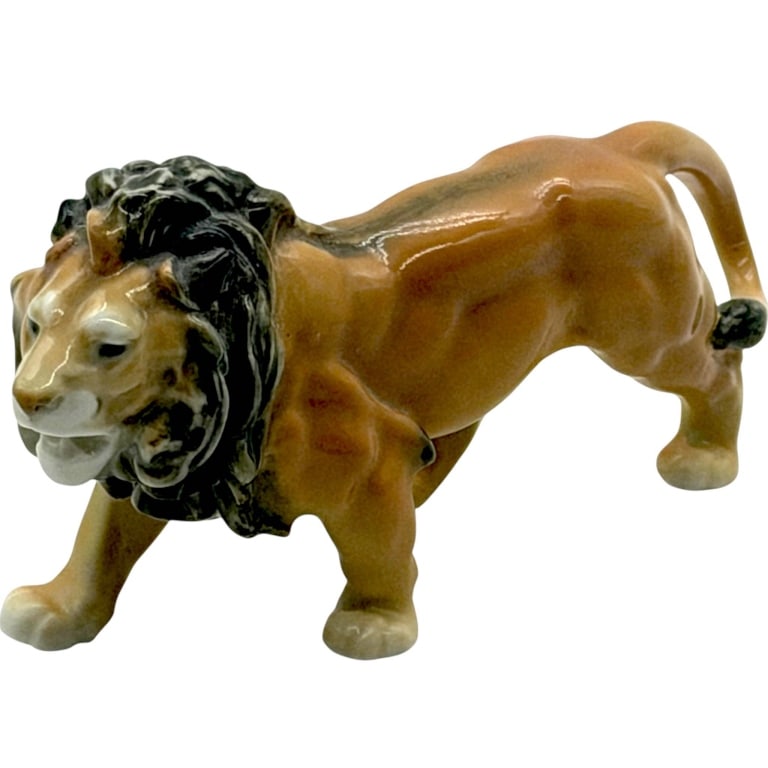 BAVARIAN PORCELAIN LION FIGURINE 7": Vintage Bavarian porcelain lion figurine depicting a powerful male lion in a dramatic walking pose. Finely modeled with a full dark mane, muscular body, expressive face, extended front paw and curled