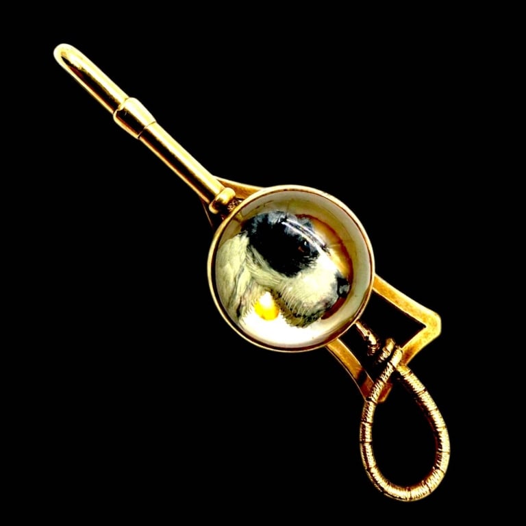 18K GOLD REVERSE PAINTED DOG TIE CLIP 2.5": Vintage 18K yellow gold tie clip featuring a distinctive circular domed crystal centerpiece with a reverse-painted portrait of a black-and-white dog, possibly a terrier-type breed. The detailed miniat