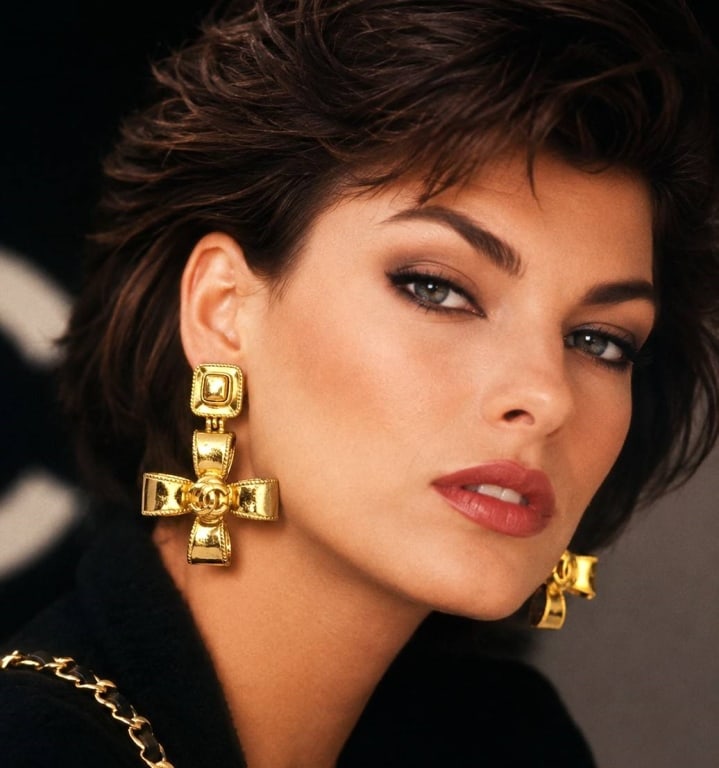 CHANEL RARE LAGERFELD ERA BOW CC EARRINGS 2": Vintage Chanel clip-on drop earrings from the Karl Lagerfeld era, featuring sculptural gold-tone ribbon bows centered with raised interlocking CC logos. Each earring is suspended from a dimensional re