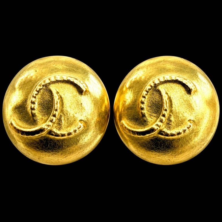 CHANEL LAGERFELD ERA CC CLIP EARRINGS 1": CHANEL Karl Lagerfeld-era gold-tone clip-on earrings featuring a bold domed circular design with an oversized raised interlocking CC motif across the face. Classic sculptural statement styling with su