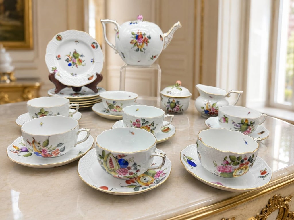 HEREND FRUIT & FLOWER TEA SERVICE: Beautiful assembled Herend porcelain tea service decorated with vibrant hand-painted arrangements of fruit, flowers, vegetables, and delicate insects. The white porcelain forms feature molded basket-w