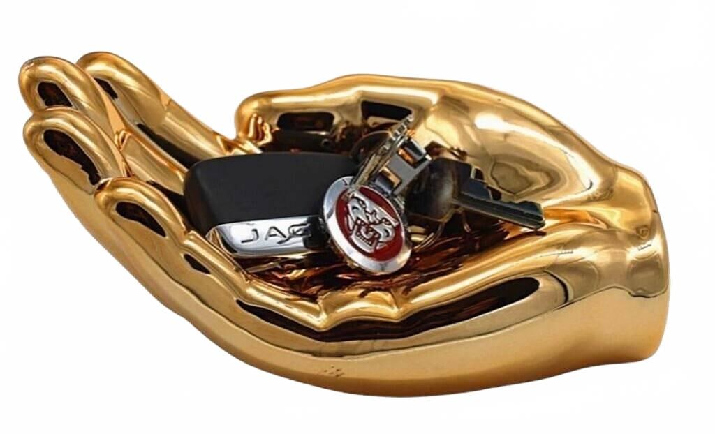 NOVELTY BRONZE HAND DECORATION DISH 7.5": The Bronze Hand Tray Decoration adds a sophisticated touch to any space with its elegant design and metallic finish. Perfect for holding trinkets or as a decorative statement piece, it effortlessly