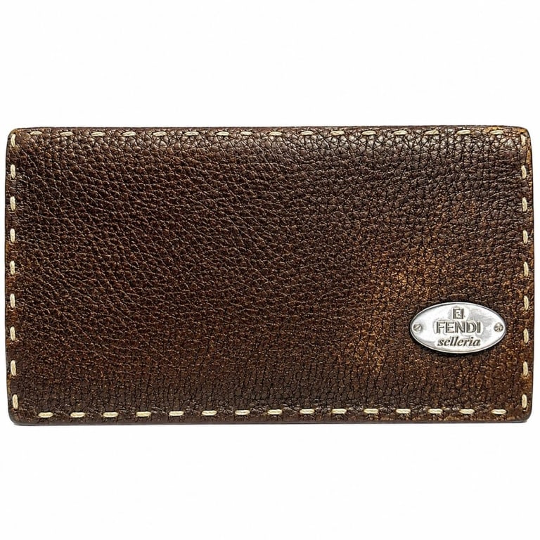 FENDI SELLERIA BROWN LEATHER WALLET W/ COA 7.5": Fendi Selleria continental wallet crafted in rich brown pebbled leather with signature contrasting hand stitching and silver-tone oval Fendi Selleria logo plaque. Classic elongated design opens to a w