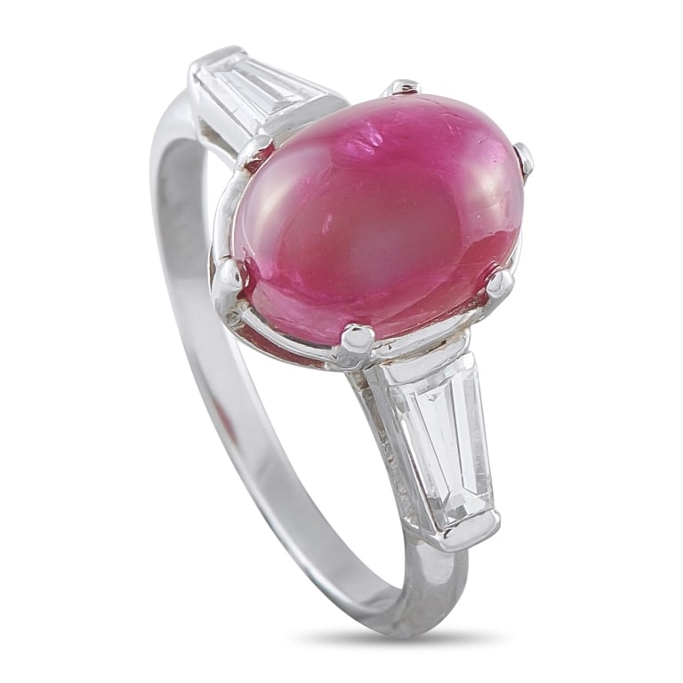 ANTIQUE PLATINUM DIAMOND AND RUBY CABOCHON RING: This Art Deco-style ring is crafted in platinum and weighs 6.2 grams. It showcases a 5.00 carat cabochon-cut ruby center stone flanked by tapered baguette diamonds totaling approximately 0.50 carats. 
