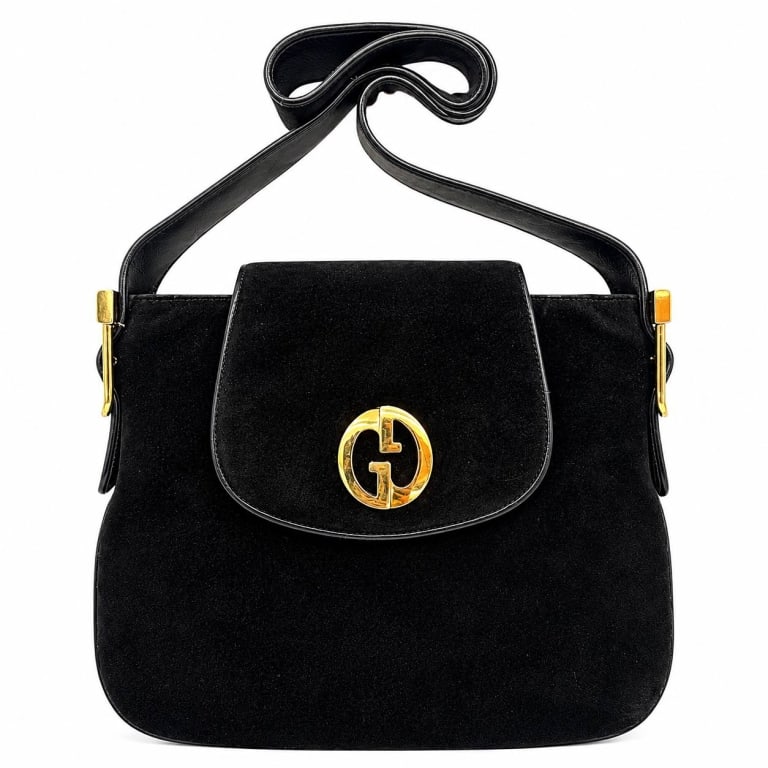 GUCCI RARE 1973 BLACK SUEDE SHOULDER BAG 9": Gucci 1973 shoulder bag crafted in rich black suede with black leather trim and striking gold-tone hardware. The structured silhouette features a rounded front flap accented by the collection's distin