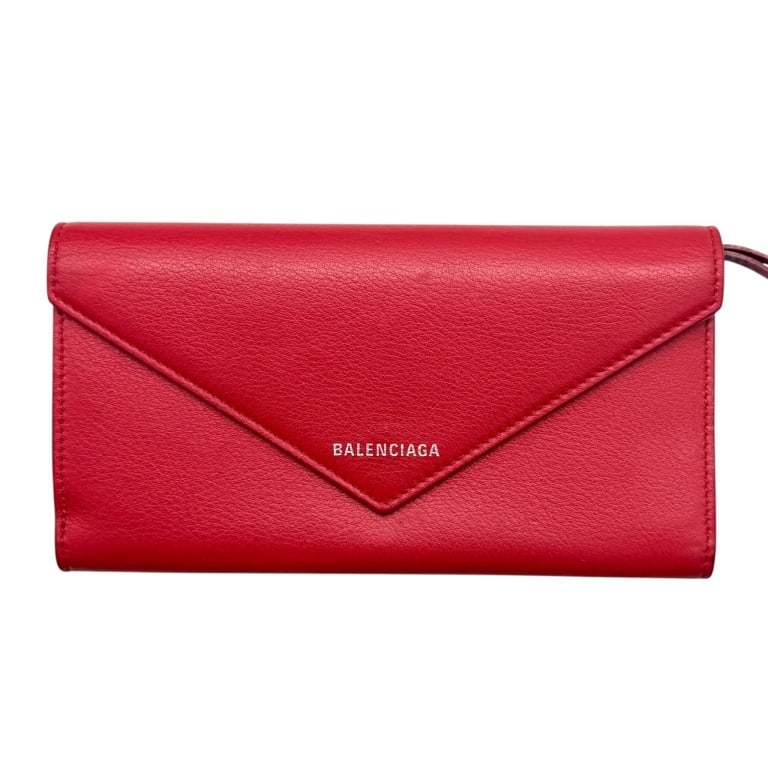 BALENCIAGA RED LEATHER ENVELOPE WALLET 7": Balenciaga continental envelope wallet crafted in vibrant red grained leather with a sleek elongated silhouette and pointed envelope-style snap flap. The front is finished with silver-tone BALENCIAGA 