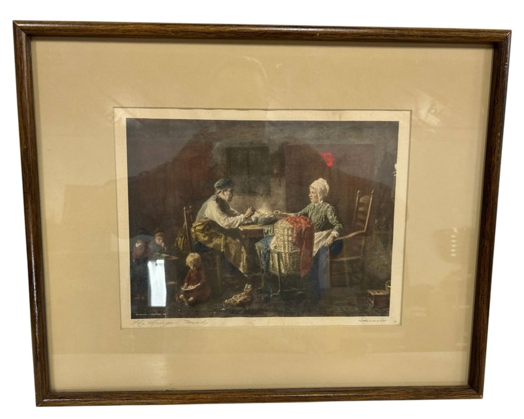 VINTAGE "THE FRUGAL MEAL" FRAMED PRINT 21": Vintage framed genre print titled "The Frugal Meal," depicting a warmly rendered domestic interior with an elderly couple seated at a table and young children gathered nearby. The image bears the