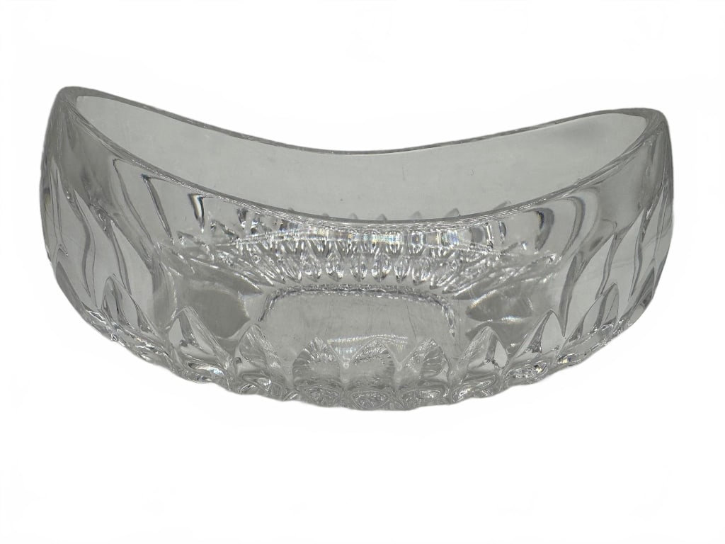 Waterford Style Cut Glass Oval Bowl: Elegant cut glass bowl in the Waterford style, featuring a classic oval shape with a scalloped rim and intricate faceted detailing. Measures approximately 9 inches long. Perfect for serving or decorat
