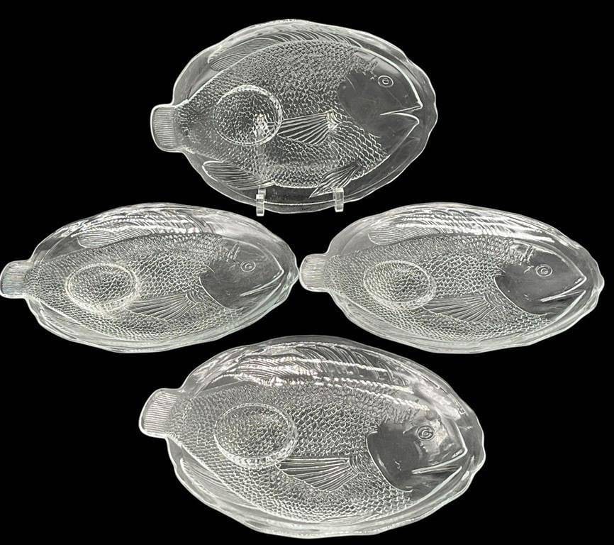 VINTAGE PRESSED GLASS FISH PLATTER SET: THIS WHIMSICAL FOUR PIECE SET OF VINTAGE PRESSED GLASS PLATTERS IS CRAFTED IN THE HIGHLY DETAILED SHAPE OF ANGLER FISH. EACH CLEAR GLASS PLATTER SHOWCASES INTRICATE TEXTURAL ELEMENTS, INCLUDING