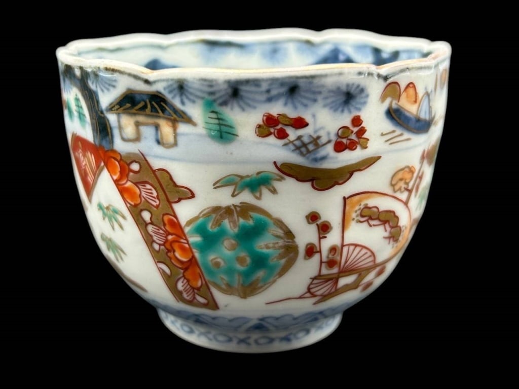 ANTIQUE JAPANESE IMARI PORCELAIN BOWL 3.5": Antique Japanese porcelain bowl featuring finely hand-painted polychrome decoration in the Imari tradition. The scalloped rim surrounds an elaborate composition of stylized floral sprays, auspicious m