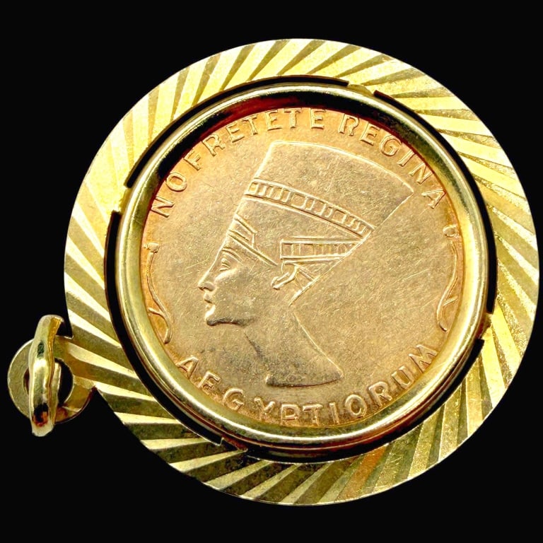 14K GOLD NEFERTITI & SUN COIN PENDANT 3.8G: 14K GOLD NEFERTITI AFRICART ORNUM COIN PENDANT 3.8G | | Vintage 14K yellow gold Egyptian-inspired coin pendant featuring a central medallion with the profile of Queen Nefertiti wearing her distinctive