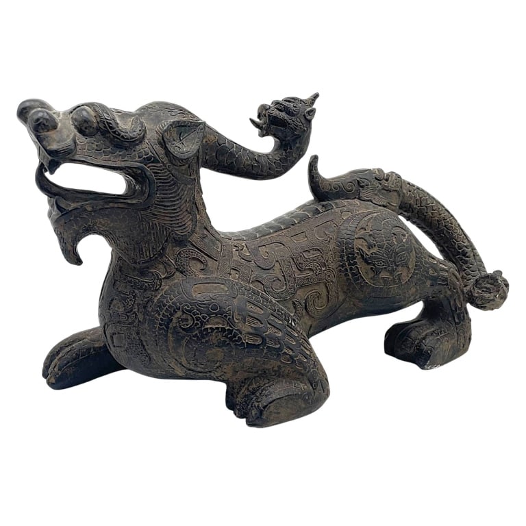 ASIAN BRONZE DRAGON QILIN SCULPTURE 14": Large Asian bronze or bronze-tone sculpture depicting a highly stylized mythical beast, likely a qilin or dragon-lion guardian figure, modeled in a powerful recumbent stance. The creature features an 