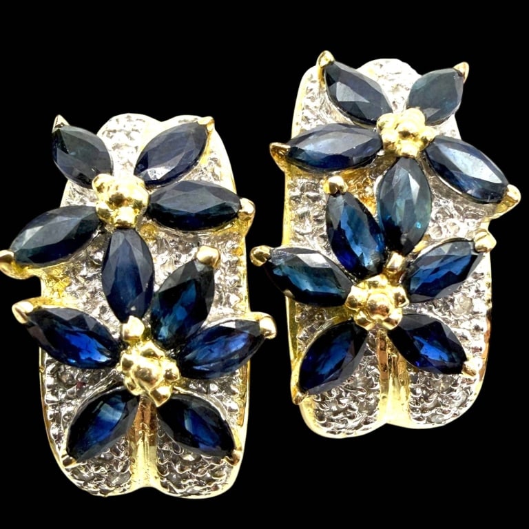 SAPPHIRE & DIAMOND 14K GOLD FLORAL EARRINGS: Striking 14K gold floral earrings, each designed with two overlapping blossoms set with marquise-cut deep blue sapphires and accented by sparkling round-cut diamonds. Textured white-gold foliage and p