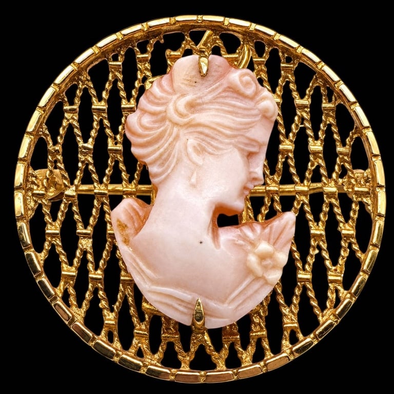 14K GOLD CARVED CAMEO BROOCH: 14K GOLD CARVED CORAL CAMEO BROOCH 5.4G | | Elegant 14K yellow gold brooch centered by a finely carved pink coral cameo depicting a classical woman in profile holding a flower. The dimensional carving