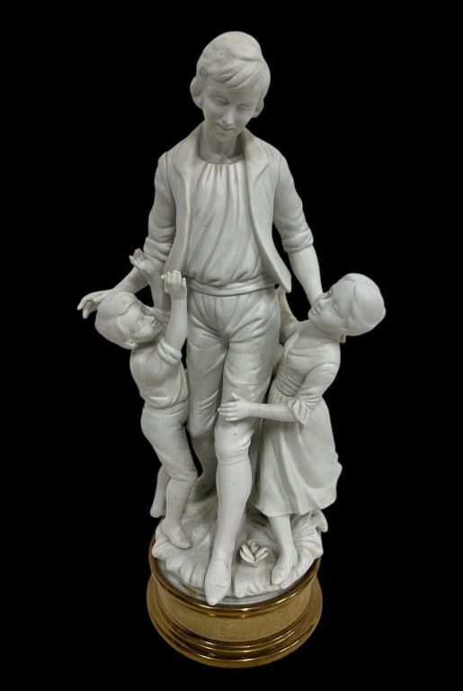 BISQUE PORCELAIN FIGURAL GROUP CHILDREN 15": Elegant white bisque porcelain figural group depicting an older youth surrounded by two younger children in an affectionate pastoral composition. Finely modeled with expressive faces, naturalistic pos