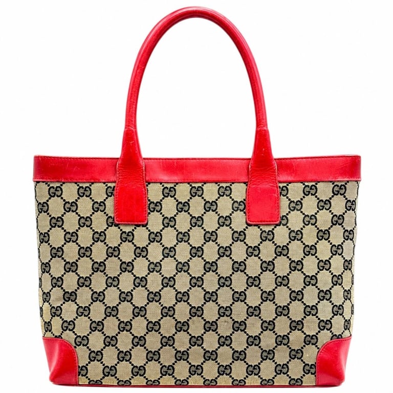 GUCCI GG CANVAS RED LEATHER TOTE 14": Vintage Gucci GG Canvas tote, model 002.1119 / 002058, crafted in beige and black monogram GG canvas with striking red leather trim, reinforced leather corners and double rolled leather handles. The c
