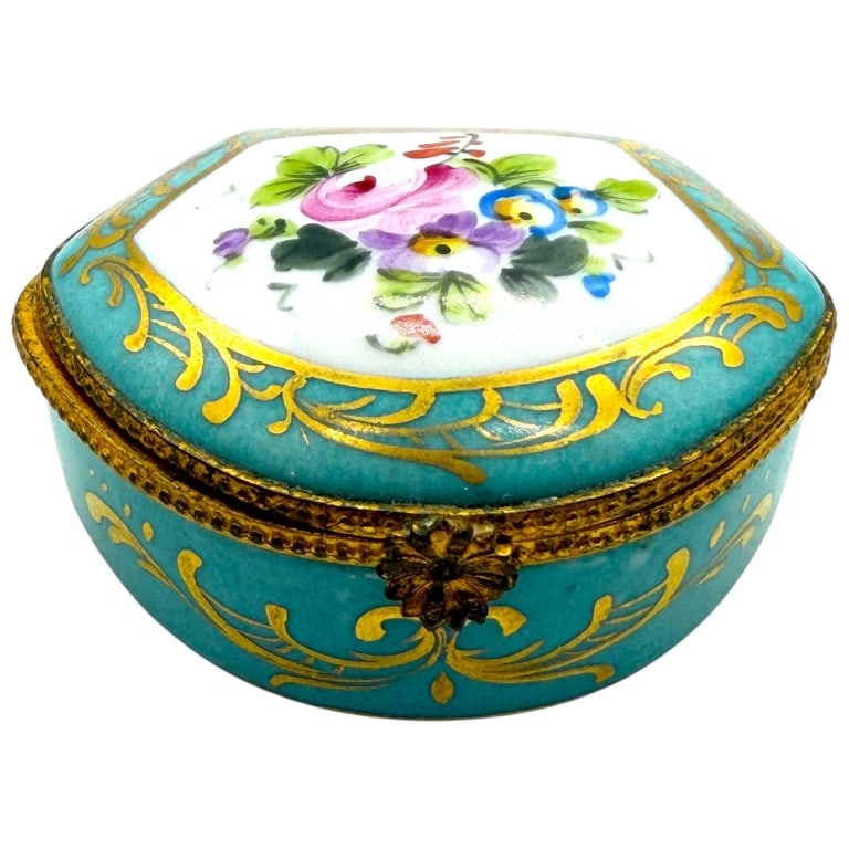 LIMOGES PEINT MAIN FLORAL TRINKET BOX 2.5": Charming miniature French Limoges porcelain hinged trinket or pill box, hand painted in a vibrant turquoise-blue ground with elaborate raised gilt scrollwork. The shaped lid centers a colorful floral 