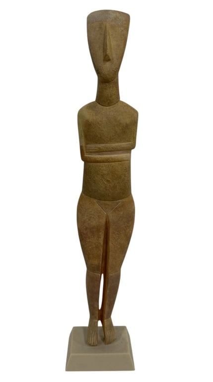CYCLADIC STYLE MARBLE IDOL FIGURE 26": Tall stylized female figure inspired by ancient Cycladic sculpture, carved in a warm beige stone or marble-like material with an elongated geometric form, folded arms, simplified facial features and p