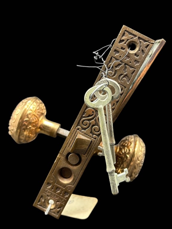 ANTIQUE ORNATE BRASS DOOR LOCK SET W KEYS 8": Antique architectural door hardware set featuring a decorative brass-toned mortise lock assembly with a pair of richly embossed round doorknobs, ornamental backplates and multiple period-style skeleto
