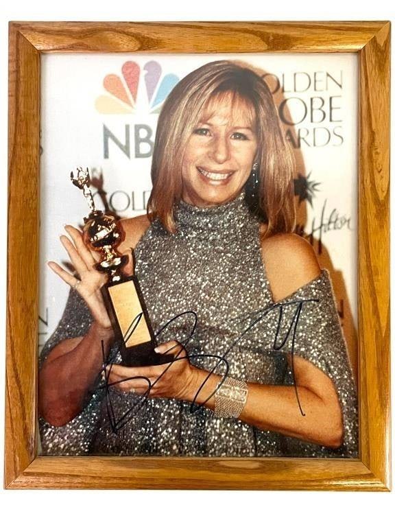 SIGNED BARBRA STREISAND GOLDEN GLOBE PHOTO 10": -SIGNED BARBRA STREISAND GOLDEN GLOBE PHOTO IN WOOD FRAME | | | -Framed 8" x 10" color photo showing Barbra Streisand posing with a Golden Globe trophy on the NBC/Golden Globe step-and-repeat backdrop