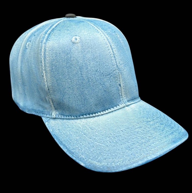 CERAMIC DENIM BASEBALL CAP SCULPTURE 10": Whimsical trompe l'oeil ceramic sculpture modeled as a classic baseball cap, realistically finished to resemble faded blue denim. The dimensional form features a curved bill, paneled crown, stitched s