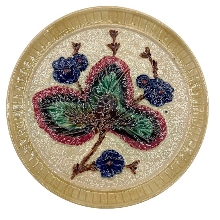 MAJOLICA BUTTERFLY FLORAL PLATE 10": Decorative majolica-style ceramic plate featuring a large raised butterfly surrounded by dimensional blue flowers and scrolling brown branches. The butterfly is richly modeled in shades of rose pink, 