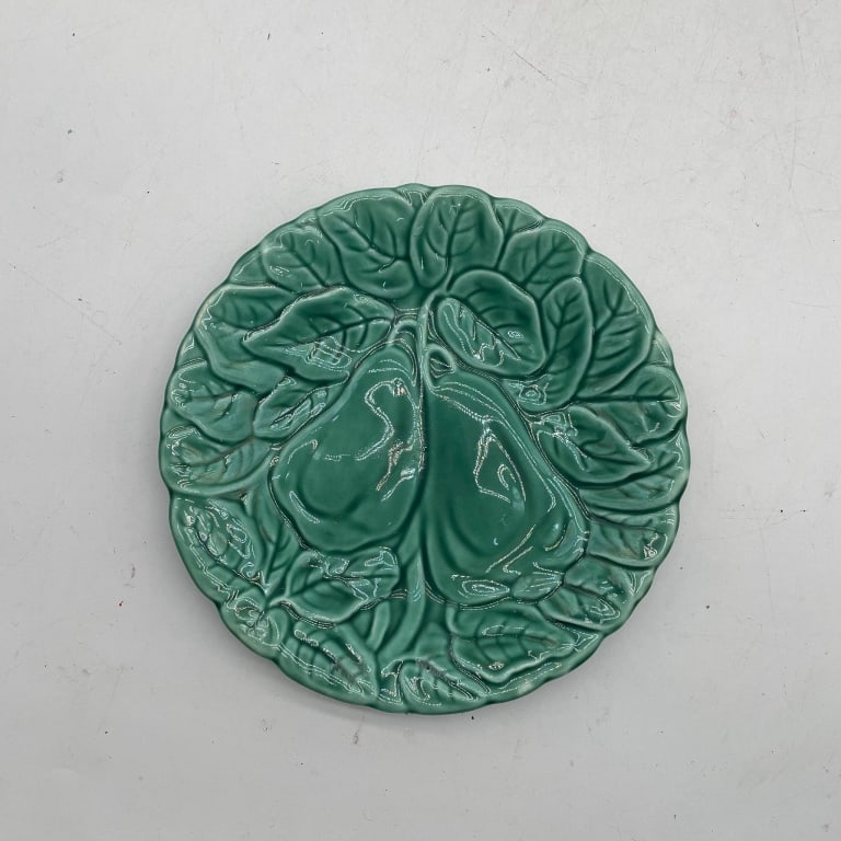 GREEN GLAZED FLORAL RELIEF CERAMIC PLATE 8": Decorative ceramic plate featuring a rich emerald green glaze over an elaborate deeply molded floral and foliate design. The surface is sculpted with a large central blossom surrounded by overlapping 