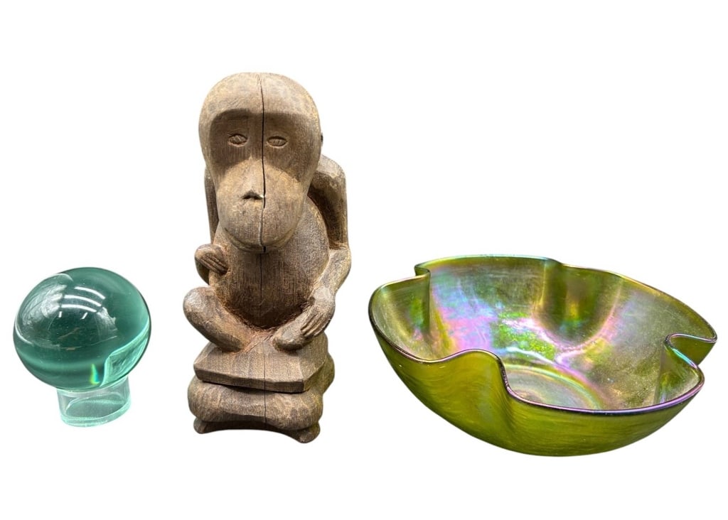 VINTAGE DECORATIVE OBJECTS MONKEY & ART GLASS 8": Eclectic estate grouping of three decorative objects including a hand-carved wood monkey figure, an iridescent art glass bowl and a green glass crystal-style sphere. The carved monkey features a styli