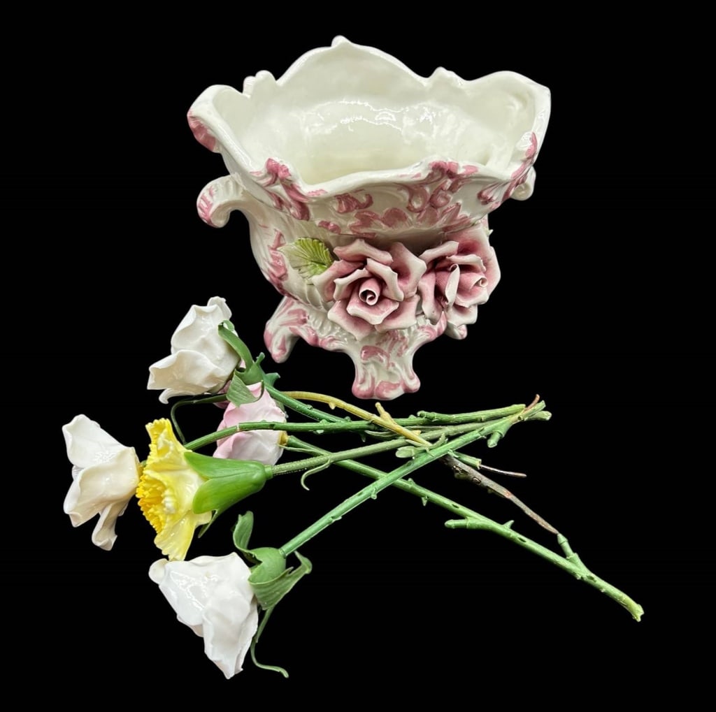 PORCELAIN ROSE CACHEPOT & FLOWERS 8": harming vintage porcelain decorative grouping featuring an ornate footed cachepot or jardiniere accompanied by a collection of individual porcelain flowers. The cream-white cachepot is richly modeled 