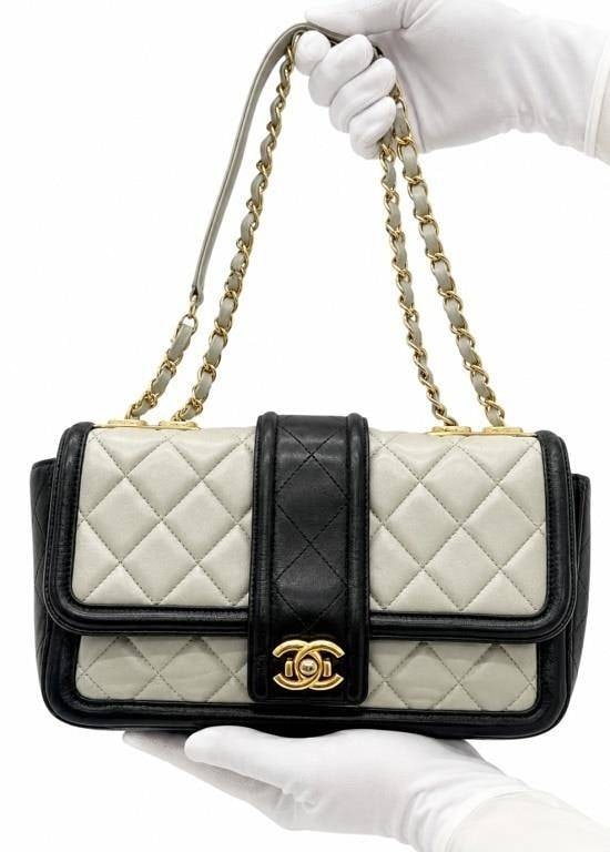 CHANEL BI-COLOR CLASSIC FLAP SHOULDER BAG 10": An exceedinly rare vintage Chanel shoulder bag crafted in luxurious quilted lambskin leather featuring an elegant ivory and black bi-color design with signature diamond quilting. The bag is accented w