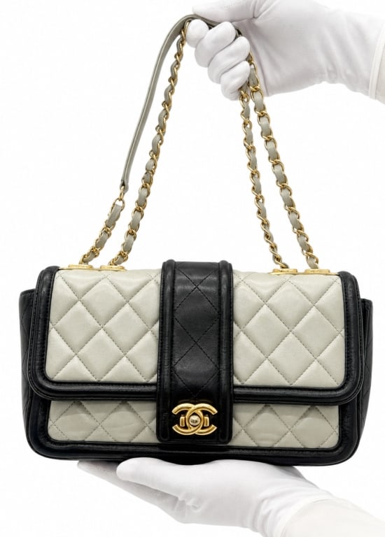 CHANEL BI-COLOR CLASSIC FLAP SHOULDER BAG 10": An exceedinly rare vintage Chanel shoulder bag crafted in luxurious quilted lambskin leather featuring an elegant ivory and black bi-color design with signature diamond quilting. The bag is accented w