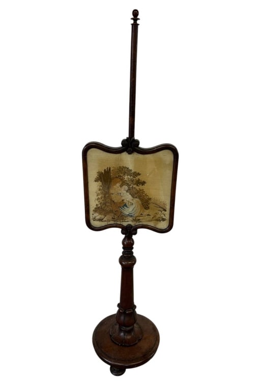 ANTIQUE VICTORIAN NEEDLEPOINT POLE SCREEN 57": Antique Victorian-style mahogany pole screen featuring an adjustable framed needlepoint panel depicting a romantic pastoral scene with a seated woman and companion amid trees and foliage. The shaped d