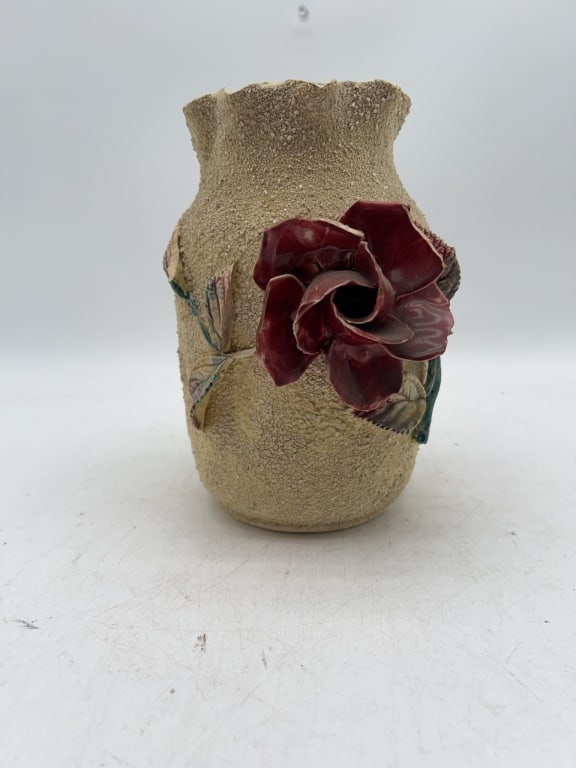 Textured Ceramic Vase with Applied Rose Motif: Ceramic vase with an exterior textured sandy finish and a prominent applied deep red rose and leaves. Approximately 7.5 inches tall and 4 inches in diameter at the top. And 4.5 wide. Classic decorativ