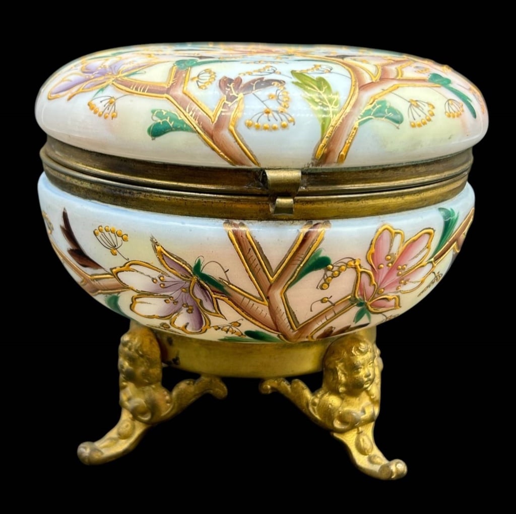 HAND PAINTED PORCELAIN FLORAL BOX ON ORMOLU 5": Elegant round porcelain covered trinket or jewelry box richly hand painted with flowering branches, blossoms and foliage in soft pink, lavender, green and brown tones, accented throughout with raised 